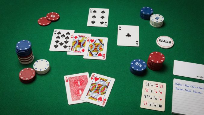 Overhead photo of a clean Texas Hold’em setup on green felt: A♥ K♥ as
