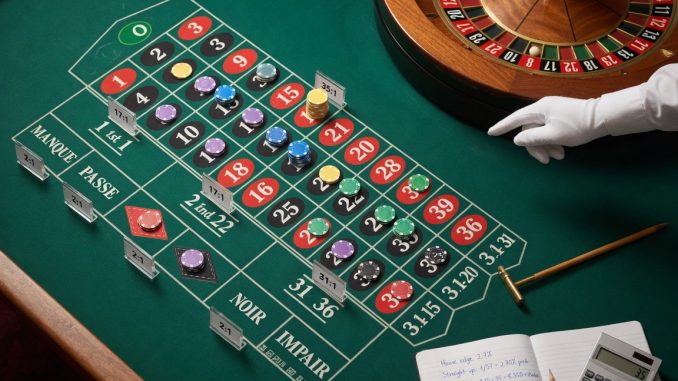Overhead photo of a European single-zero roulette table: chips arranged on various bet types
