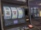 Photographic close-up of a modern slot machine with subtle transparent overlays labeled RNG, RTP,