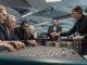 Editorial photo of a modern casino roulette table showing the dealer releasing the ball,